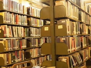 Photo of books on shelves in a library.