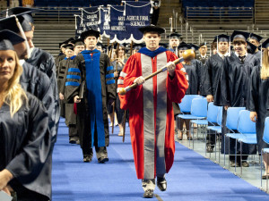 University Marshall Robert Melton led the opening processional during Summer Commencement ceremonies on Aug. 8 at the Bryce Jordan Center on the University Park campus. The mace carried by Dr. Melton is traditionally carried at the front of all graduation processions and was carved from a newel post from the original Old Main building.